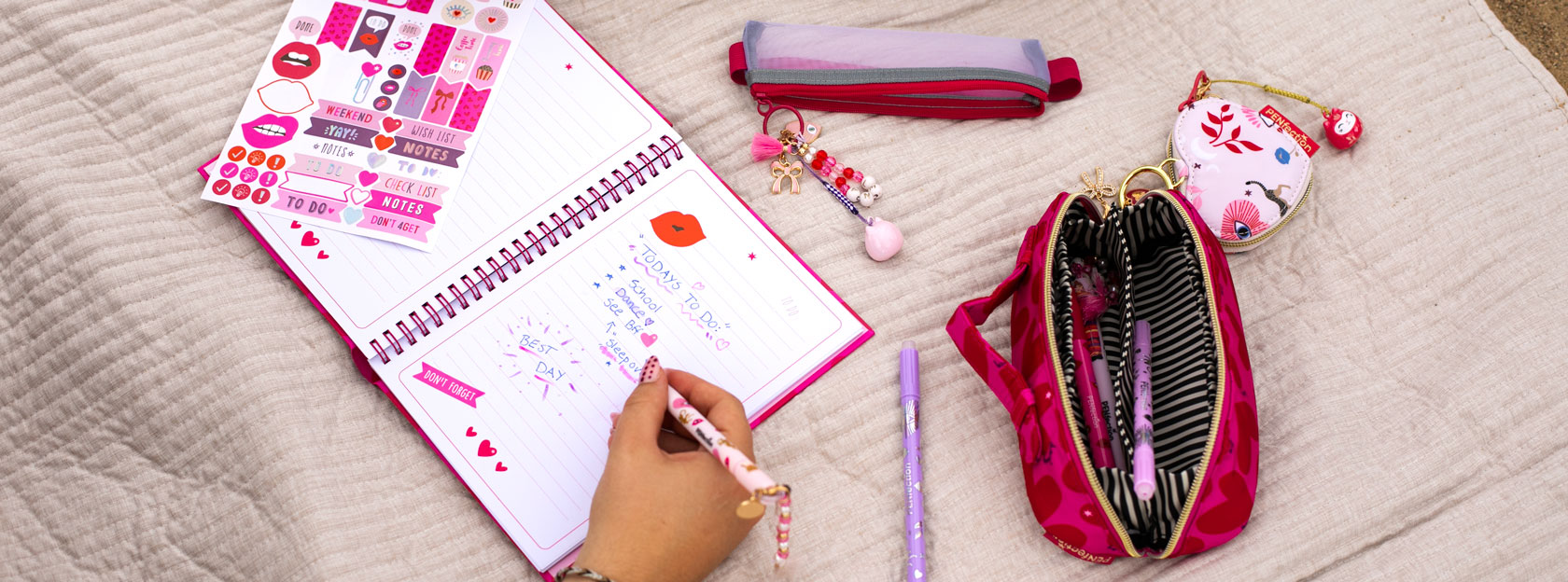 Liebevoll designtes Notizbuch, Gelstite mit Anhänger, Schlampertasche auf einer Decke am Strand mit PENfection by Depesche