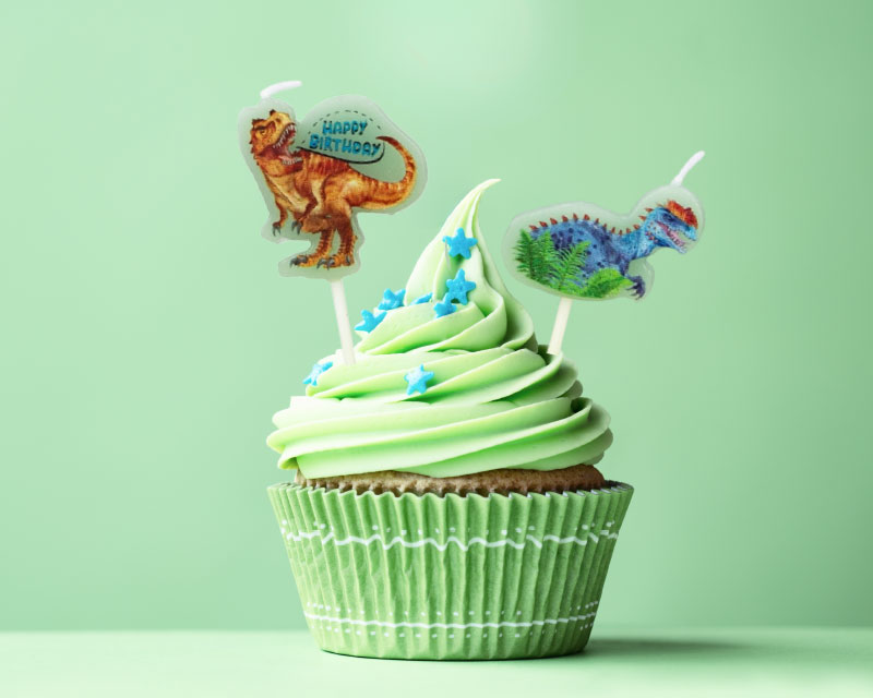 Geburtstagsmuffin mit Dinosaurier-Kerzen