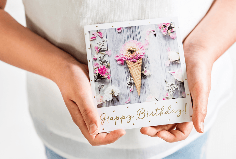 Biglietto di auguri con la scritta “Happy Birthday” nelle mani di una donna