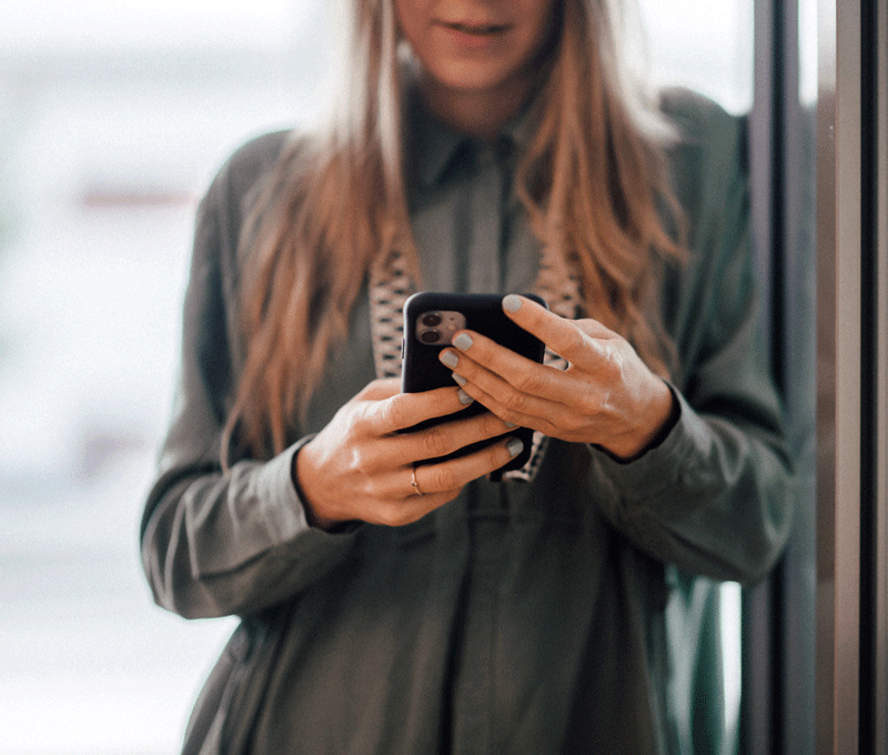 Depesche Mitarbeiterin mit Blick ins Smartphone