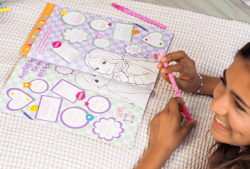 Una niña feliz pinta y hace puzzles en la revista TOPModel