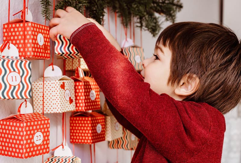Un enfant ouvre joyeusement son calendrier de l'Avent DIY