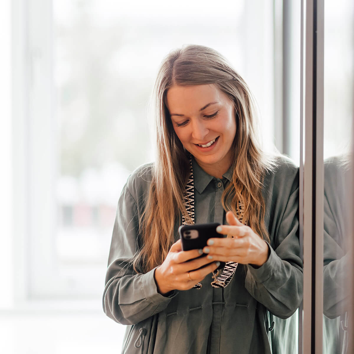 Lächelnde Depesche-Mitarbeiterin am Smartphone