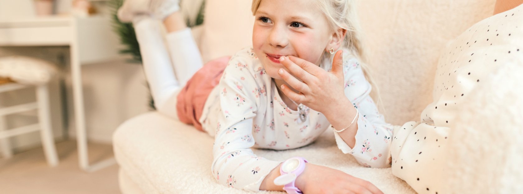 Lächelndes Mädchen mit Lipgloss aus der Uhr für Kinder