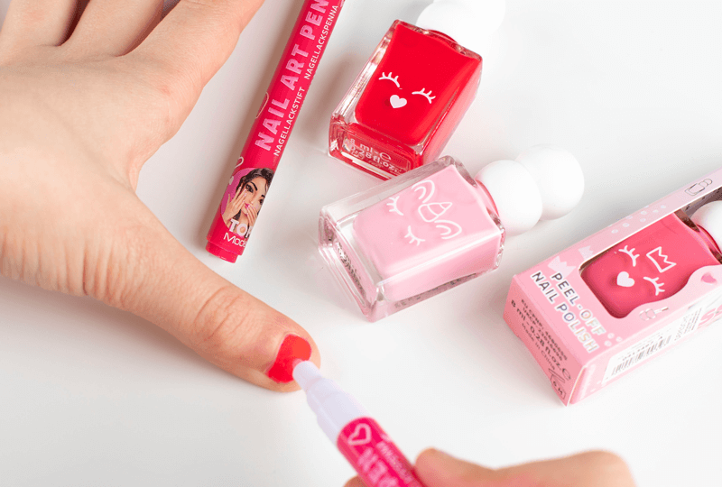 Mädchenhände mit roten, wasserbasiertem Nagellack